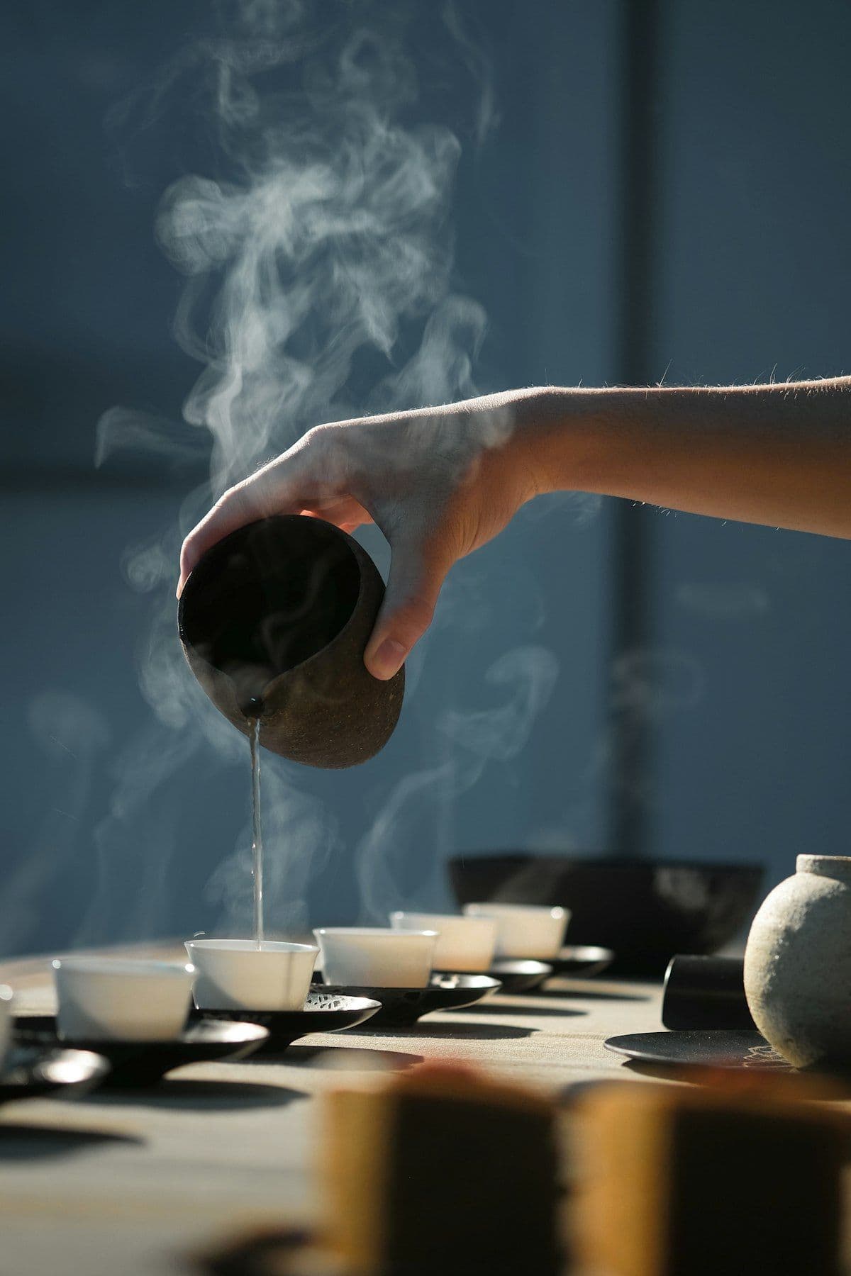 Chá sendo servido em xícaras tradicionais japonesas, com vapor subindo
