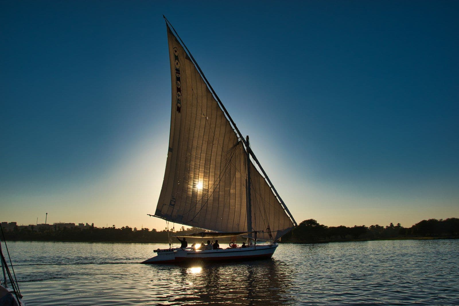 Barco à vela tradicional (felucca) navegando no Rio Nilo