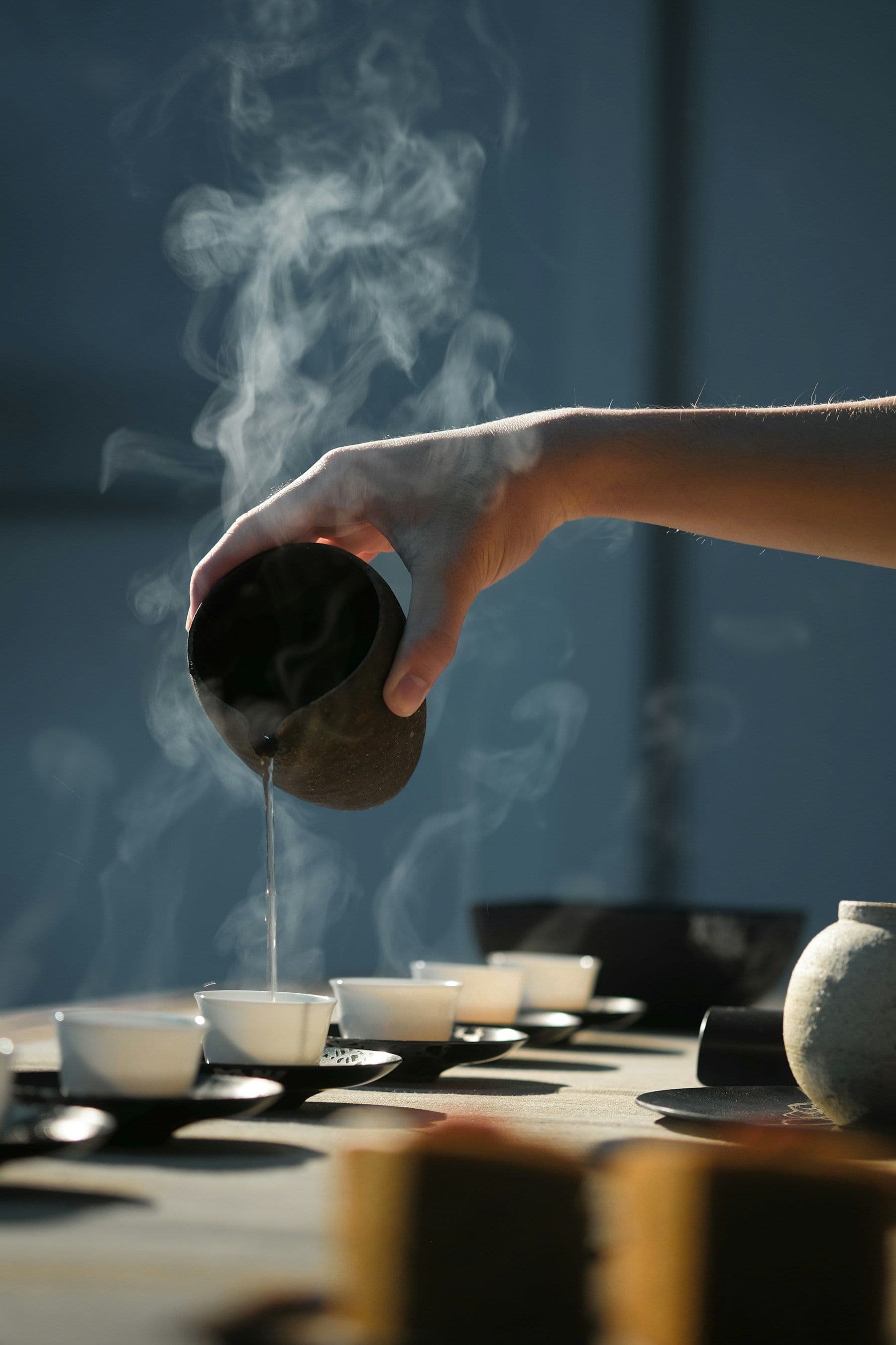 Chá sendo servido em xícaras tradicionais japonesas, com vapor subindo
