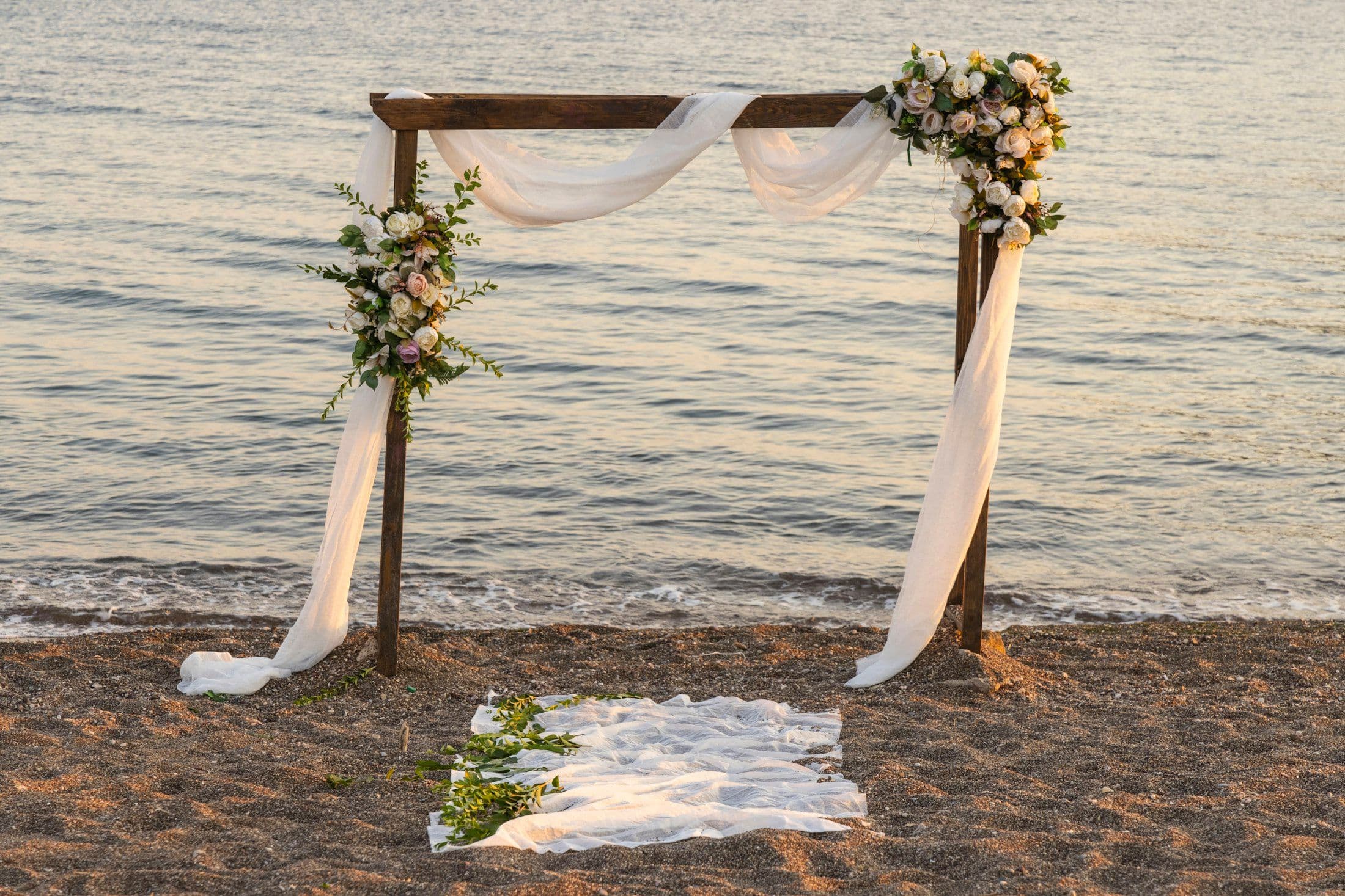 Estrutura de casamento montada à beira-mar ao entardecer