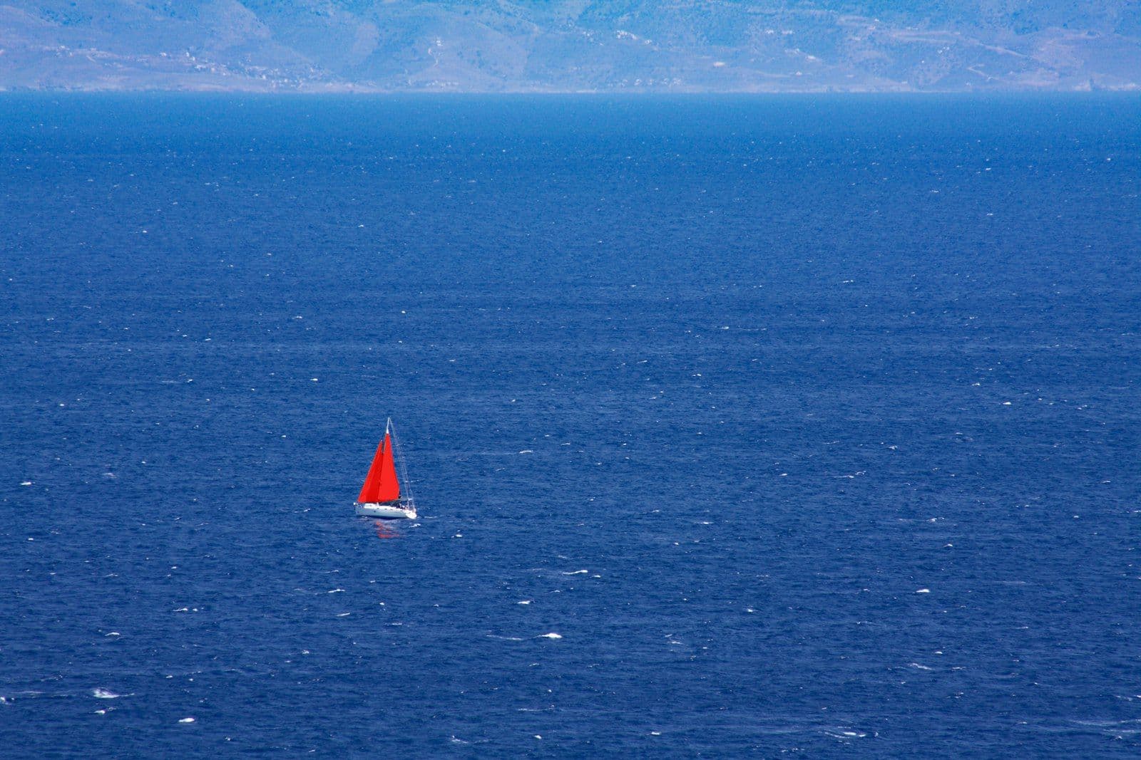 Veleiro navegando em mar azul-turquesa no Egeu